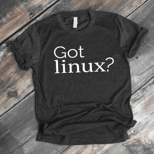 Peut inclure: Un t-shirt gris foncé avec le texte "Got linux?" imprimé en blanc sur le devant.