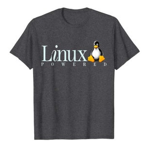 May include: A dark heather grey t-shirt with a white "Linux Powered" text and a cartoon penguin graphic.
