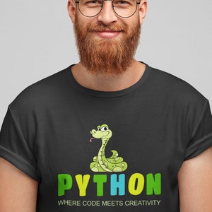Peut inclure: T-shirt noir avec un serpent de dessin animé et le mot "PYTHON" en vert, jaune et bleu. Le texte "WHERE CODE MEETS CREATIVITY" est en dessous du mot "PYTHON". Le serpent est vert avec des taches jaunes et une langue rose.