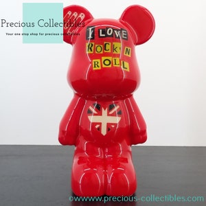 Puede incluir: Figurita de oso de cerámica roja con un diseño de corazón de Union Jack y las palabras "I LOVE ROCK N ROLL" en la parte delantera.