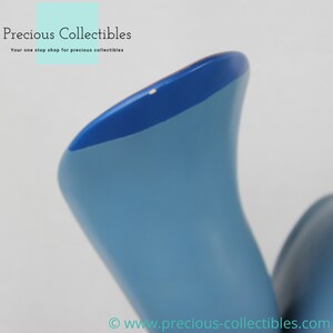 Puede incluir: Primer plano de una figurita de cer&aacute;mica azul y azul claro con una superficie lisa y redondeada. La figurita tiene una peque&ntilde;a marca blanca en la parte superior.