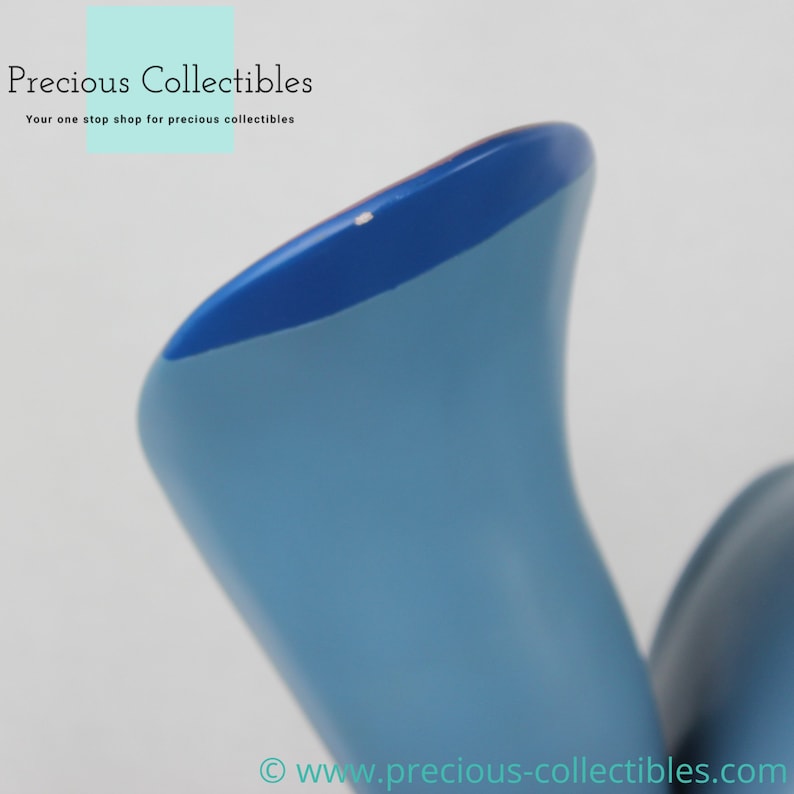 Puede incluir: Primer plano de una figurita de cer&aacute;mica azul y azul claro con una superficie lisa y redondeada. La figurita tiene una peque&ntilde;a marca blanca en la parte superior.