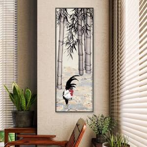 May include: A framed print featuring a rooster in a bamboo forest. The rooster has black, red, and white plumage. The bamboo is depicted in shades of gray and black. The background is a muted landscape with a touch of blue.