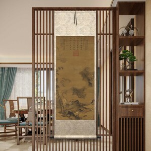 May include: A traditional Chinese scroll painting depicting a landscape scene with mountains, trees, and figures. The scroll is mounted on a wooden frame and hangs in a modern interior setting.