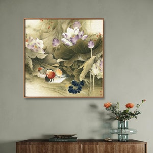 May include: A framed painting of a traditional Chinese style scene with two mandarin ducks swimming in a pond with lotus flowers and leaves. The painting is done in shades of green, brown, purple, and white.