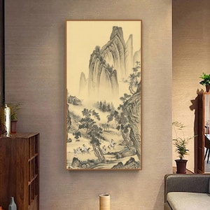 May include: A black and white ink painting of a mountain landscape with a group of people riding horses. The painting is framed in a light wood frame and is hanging on a wall.