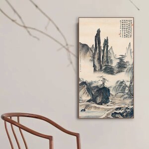 May include: A black and white ink painting of a mountain landscape with a river flowing through it. The painting is framed in a wooden frame.