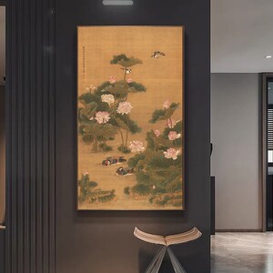 May include: A traditional Chinese painting depicting a serene scene of pink lotus flowers and birds in a pond. The painting is done on a golden background with delicate brushstrokes.