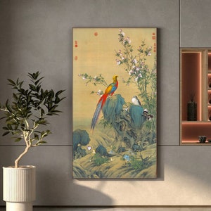 Op de afbeelding: Een vintage-stijl schilderij van een kleurrijke fazant die op een rots zit met een kleine vogel in de buurt. Het schilderij heeft een achtergrond van delicate roze bloemen en groene bladeren.