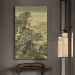 May include: A traditional Chinese painting depicting a misty mountain landscape with a series of buildings nestled among the trees. The painting is done in shades of green, brown, and white, with a subtle gold accent.