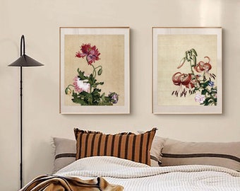 May include: Two framed floral prints with a beige background. The print on the left features a pink and red poppy flower with green leaves. The print on the right features a red lily flower with green leaves.