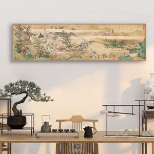 May include: A long, horizontal painting depicting a traditional Chinese landscape scene. The painting features a river, mountains, trees, and a small village. The painting is framed in a light brown wood frame.