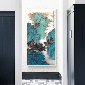 May include: A painting of a mountain landscape with a waterfall flowing down the side. The mountains are painted in shades of blue and green, and the waterfall is white. The painting is framed in a white frame.