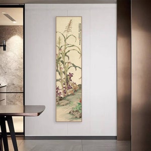May include: A vertical painting of a corn plant with purple flowers and two birds. The painting is on a light beige background with a light brown frame.