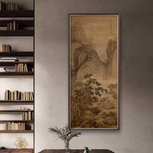 Könnte beinhalten: Ein gerahmtes Schwarzweiß-Tuschbild eines Berglands mit einem Wasserfall. Das Bild hängt an einer beigefarbenen Wand in einem modernen Wohnzimmer. Das Bild ist von einem Holzrahmen umgeben.