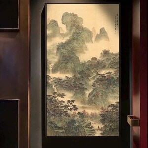 May include: A framed landscape painting depicting a misty mountain scene. The artwork features rolling green hills, trees, and a small structure, possibly a temple, with a soft, muted color palette. The painting is framed in a black border.