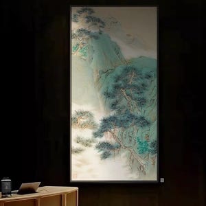 Könnte beinhalten: Gerahmtes vertikales Gemälde, das eine ruhige Berglandschaft darstellt. Das Kunstwerk zeigt eine gedämpfte Farbpalette aus Grün- und Blautönen mit detaillierten Darstellungen von Bäumen und einer nebligen Atmosphäre. Das Gemälde ist vor einem dunklen Hintergrund.