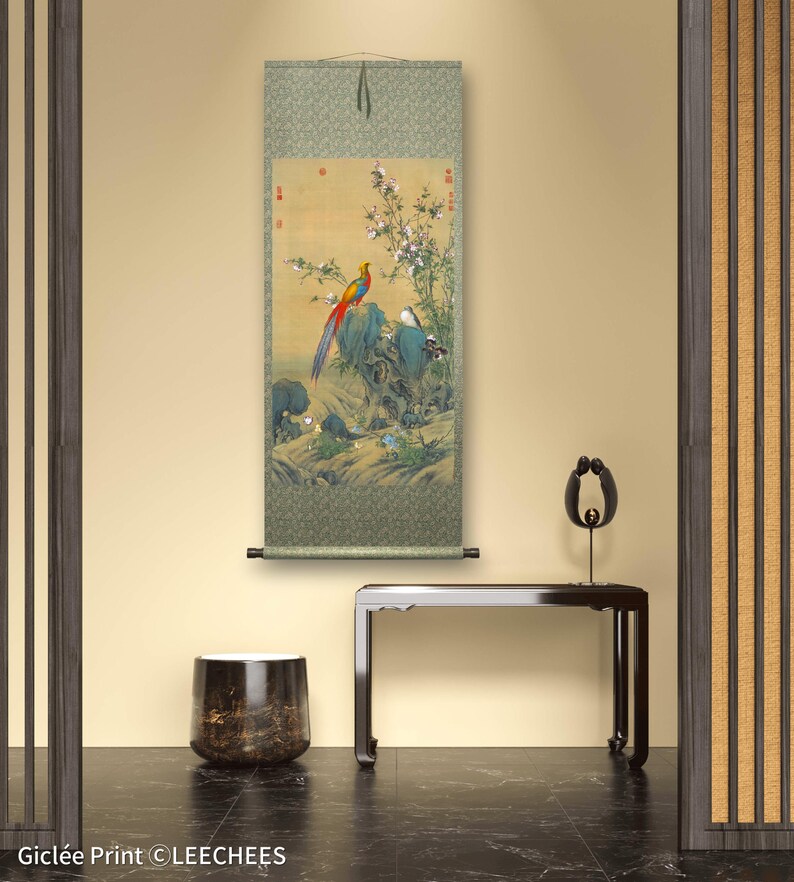Op de afbeelding: Een traditionele Japanse rol schilderij met een kleurrijke fazant die op een rots zit met een kleinere vogel in de buurt. De rol is gemonteerd op een groene achtergrond met een bloemenontwerp en heeft Chinese karakters in de bovenste hoeken.