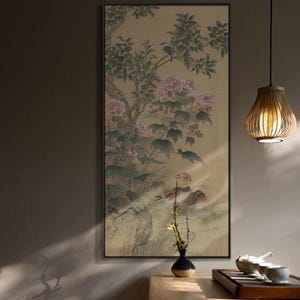 May include: A framed Asian-style painting featuring a tree with pink flowers and green leaves, with birds perched on branches. Ducks are depicted at the base of the tree. The artwork has a gold background and is in a black frame.