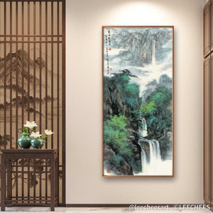 May include: A traditional Chinese ink and wash painting depicting a waterfall cascading down a mountainside. The painting is framed in a wooden frame and features a light gray background with green and blue hues. The painting is signed in Chinese characters.