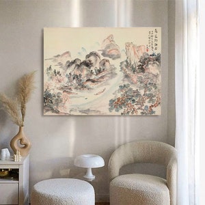 May include: A traditional Chinese ink and wash painting depicting a landscape with mountains, trees, and a river. The painting is done in shades of grey, blue, and pink, with hints of red and green. The painting is framed and ready to hang.