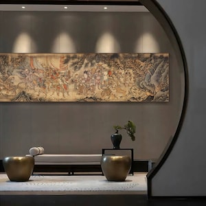 May include: A large, framed, antique-style painting of a procession of people in a landscape setting. The painting is hung on a gray wall in a modern interior with a white couch and two gold metal stools.