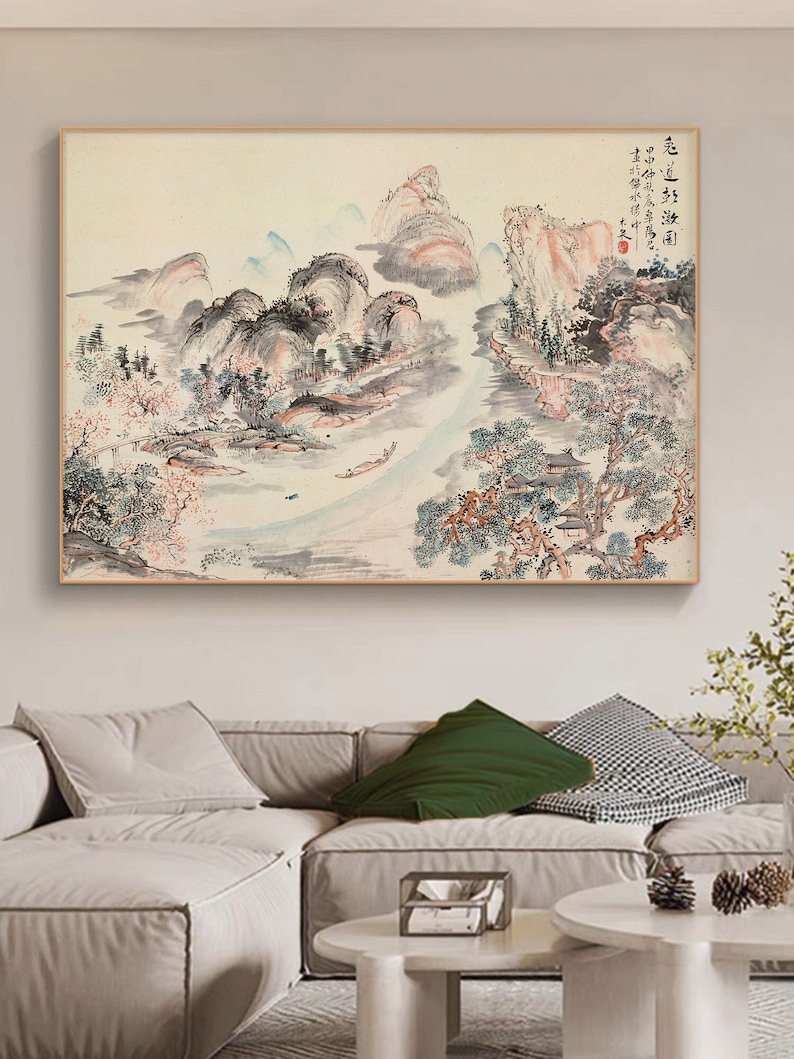 May include: A traditional Chinese landscape painting depicting a river flowing through mountains and trees. The painting is executed in shades of grey, blue, and pink, with a light background. The text in the top right corner reads "色 韵 淡 淡 幽"