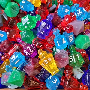 Può includere: Una collezione di dadi e bottiglie di pozione trasparenti e colorati con diversi numeri stampati su di essi. I dadi e le bottiglie sono in vetro e hanno una varietà di forme e dimensioni.