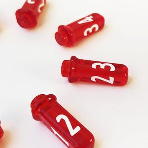 Four vial-shaped D4 dice on a white background. They have a red translucent finish with bold white numbers 1 through 4, resembling small potion bottles.