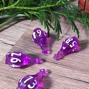 May include: Four translucent purple potion bottle-shaped dice with white numbers printed on the surface. Each die features a unique set of numbers, including 264, 19, 58, and 135, designed for tabletop gaming and role-playing activities.