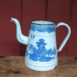 May include: White enamel teapot with a blue and white floral pattern. The teapot has a spout and a handle.