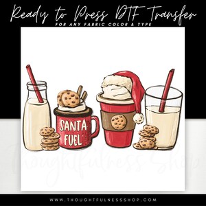May include: A digital design featuring a red cup with white whipped cream and a Santa hat, a red mug with the text "Santa Fuel", a glass of milk with a straw, and a stack of chocolate chip cookies.