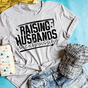 Peut inclure: Un t-shirt gris avec un texte noir qui dit "&Eacute;lever des maris est &eacute;puisant".
