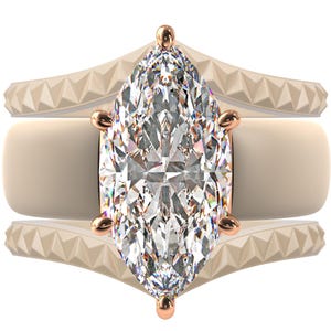 May include: A marquise-cut diamond engagement ring with a rose gold setting. The ring is flanked by two bands with a geometric design. The diamond is the focal point, sparkling with many facets. The bands are a light beige color.