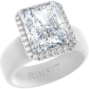 May include: A white silicone ring featuring a large rectangular radiant-cut clear stone set in a halo of smaller round clear stones. The band is smooth and matte, with the word RINFIT embossed in capital letters on the front of the ring band.