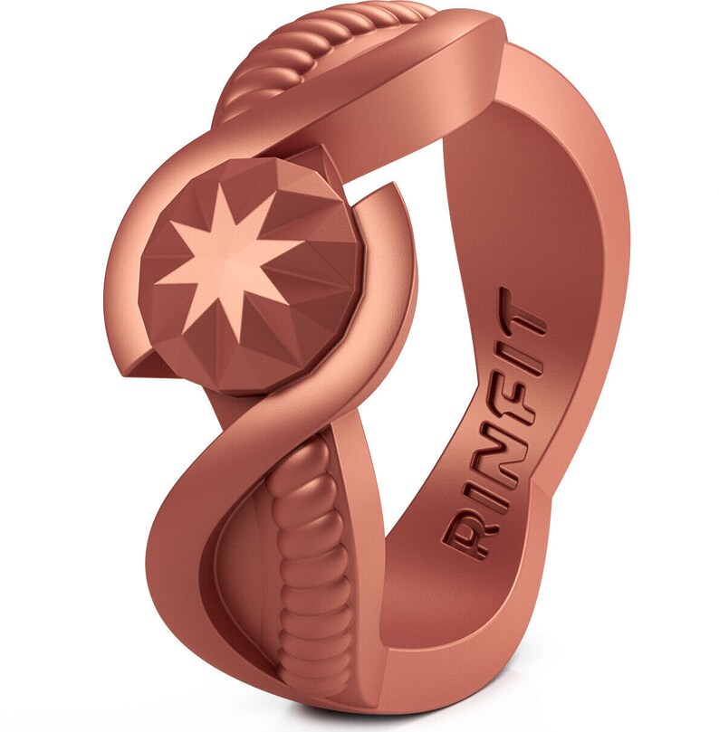 Op de afbeelding: Een ros&eacute;gouden siliconen ring met een touwachtig ontwerp en een stervormige edelsteen in het midden. De ring is gegraveerd met het woord "RINFIT".