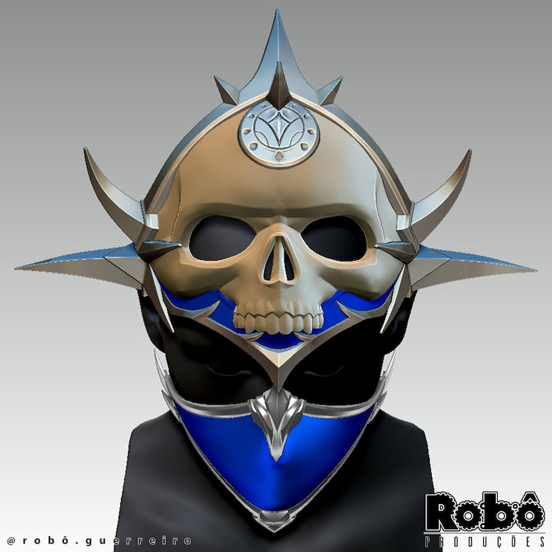 May include: A silver and blue skull mask with a pointed crown and a blue scarf. The mask has a detailed skull design with sharp teeth and a pointed chin. The crown has a circular design with a star in the center. The scarf is a dark blue color and has a pointed design at the bottom.