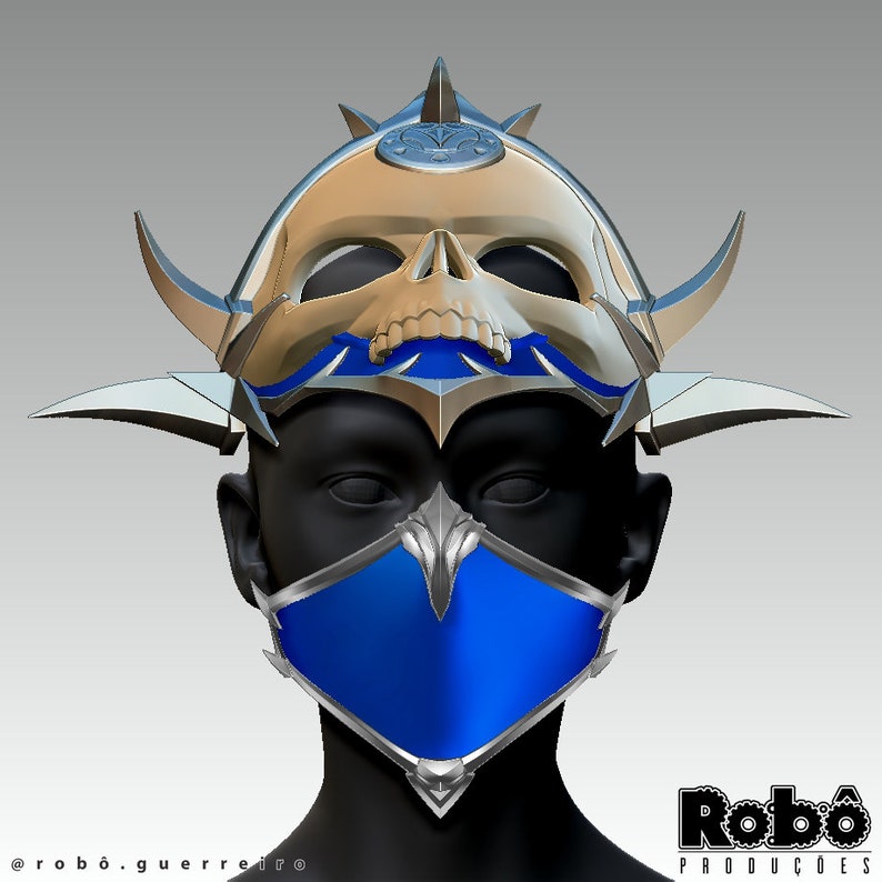 May include: A blue and silver face mask with a skull helmet on top. The helmet is gold and silver with a blue and silver trim. The mask has a sharp, angular design. The text "Rob&ocirc; Produ&ccedil;&otilde;es" is visible in the lower right corner of the image.