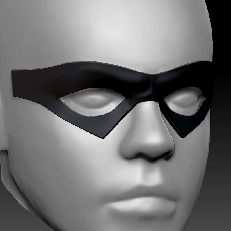 May include: A close-up of a white face mask with a black eye mask. The eye mask has a classic superhero design.