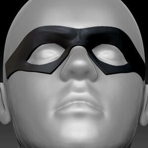 May include: A close-up of a person wearing a black eye mask. The mask covers the eyes and part of the nose. The mask has a curved shape and is made of a smooth material.