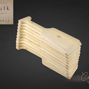 May include: A stack of 12 unfinished cedar wood chopping boards with a handle. The boards are arranged in a staggered pattern. The text "Bulk Cutting Boards" is visible in the top left corner of the image. The text "Cedar Wood" is visible in the bottom right corner of the image.