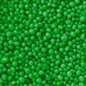 May include: A close-up image of green candy sprinkles. The sprinkles are small and round, and they are perfect for decorating cakes, cupcakes, and other desserts.