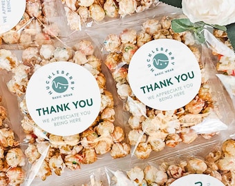 May include: Small clear bags filled with popcorn and topped with round white stickers that say "Huckleberry Basic Wear" and "Thank You We Appreciate You Being Here".