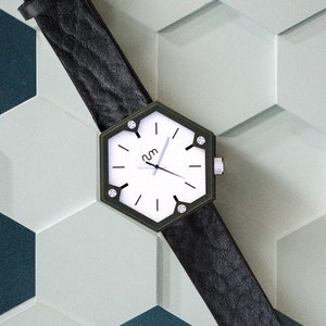 A hexagon wood watch laying on a hexagonal background