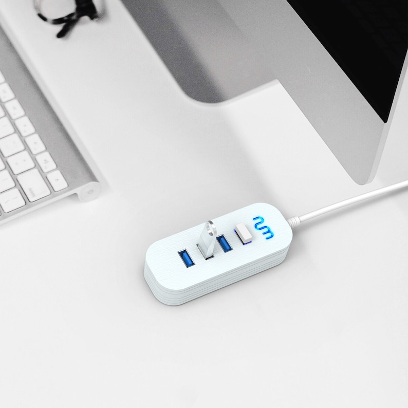 May include: A white USB hub with four ports and a blue light on each port. The hub is connected to a computer with a white cable. The text "2m" is printed on the hub.