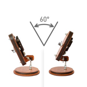 May include: A wooden phone stand with a rotating base, allowing the phone to be positioned at a 60-degree angle. The stand is made of dark wood with a natural finish.