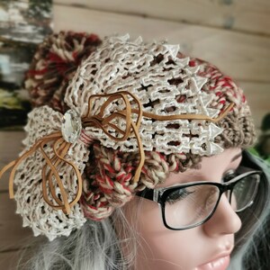 Bobble Hat. Red and beige, sparkly, embellished, pompom, chunky cable-knit. Knitted. 100% Acrylic. One size fits all.