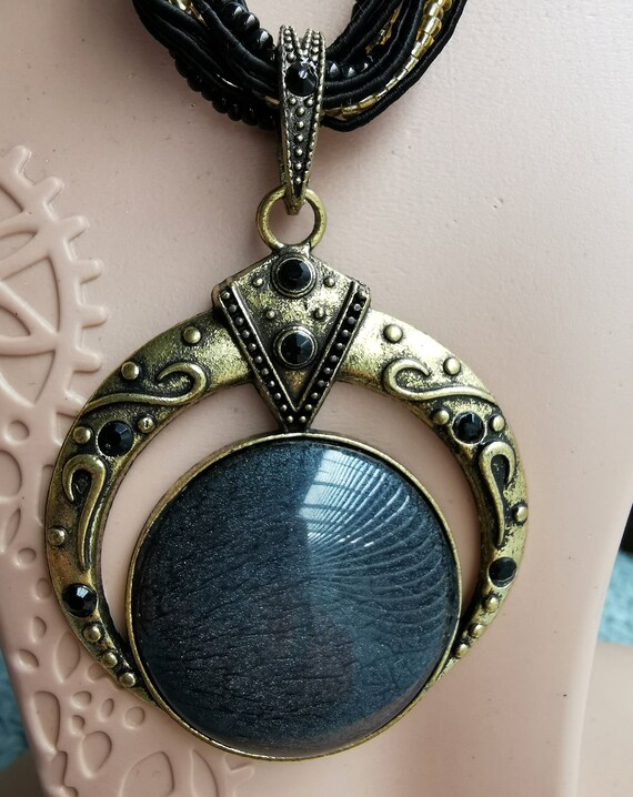 Black Resin Pendant Set in Gold-Coloured Metal, Adorned with Black Crystals, on a Faux Silk, Black & Gold Beaded Necklace
