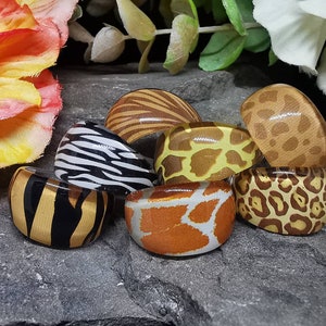 May include: Set of six colourful resin rings with different animal print designs, including zebra, giraffe, leopard, and cheetah patterns.