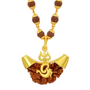 May include: A gold necklace with a brown rudraksha pendant featuring a gold Om symbol and a trident. The necklace is made of rudraksha beads.